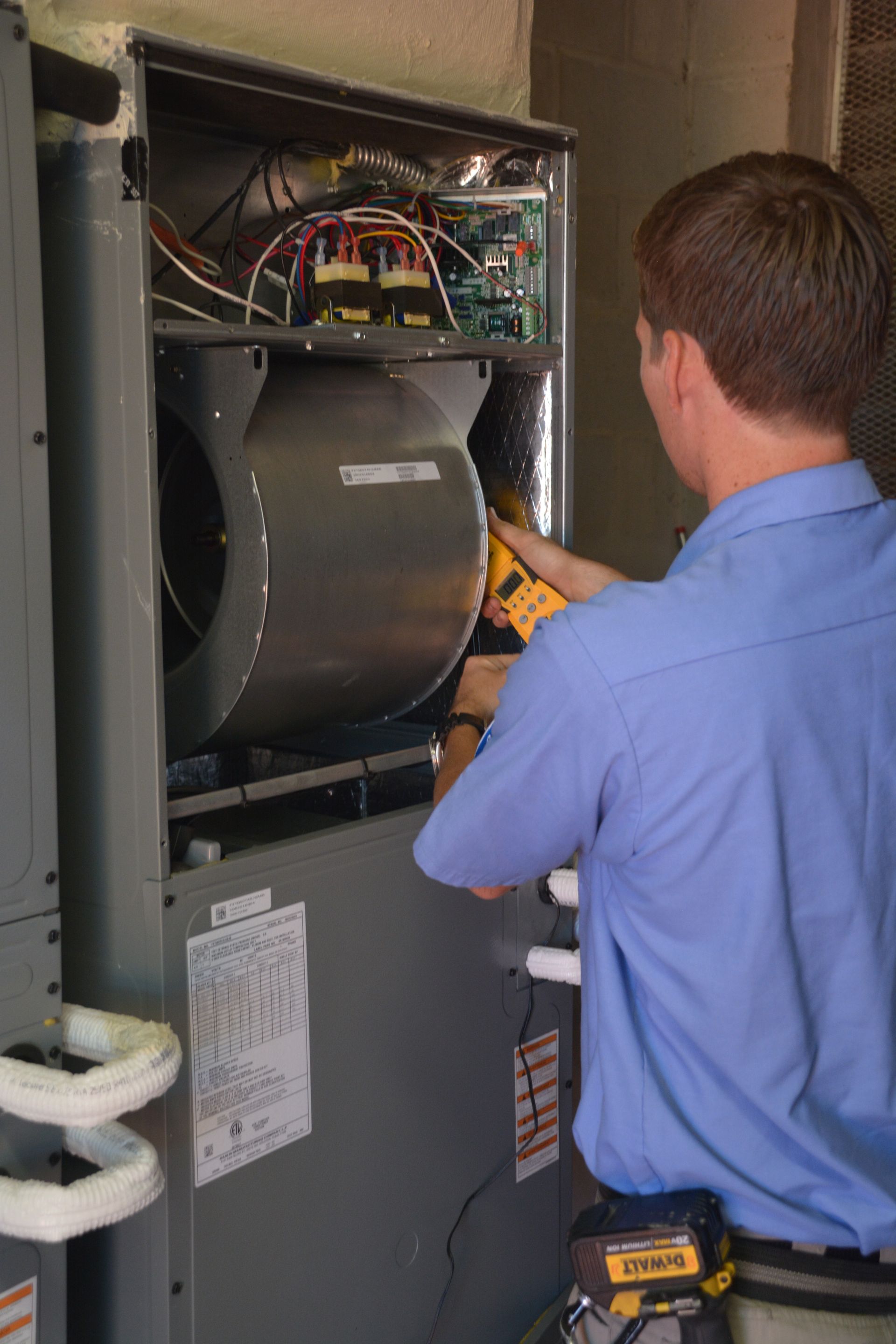 Technician inspecting electrical equipment inside an open service panel