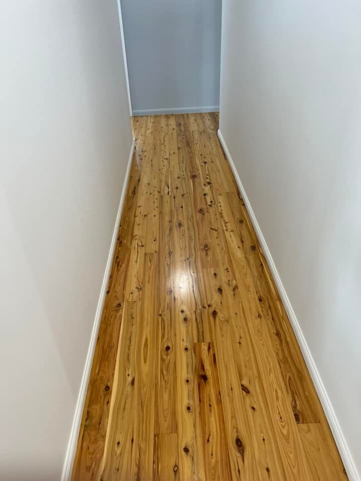 A Hallway With A Wooden Floor And White Walls — AJ's Cleaning & Floor Sanding In Woree, QLD