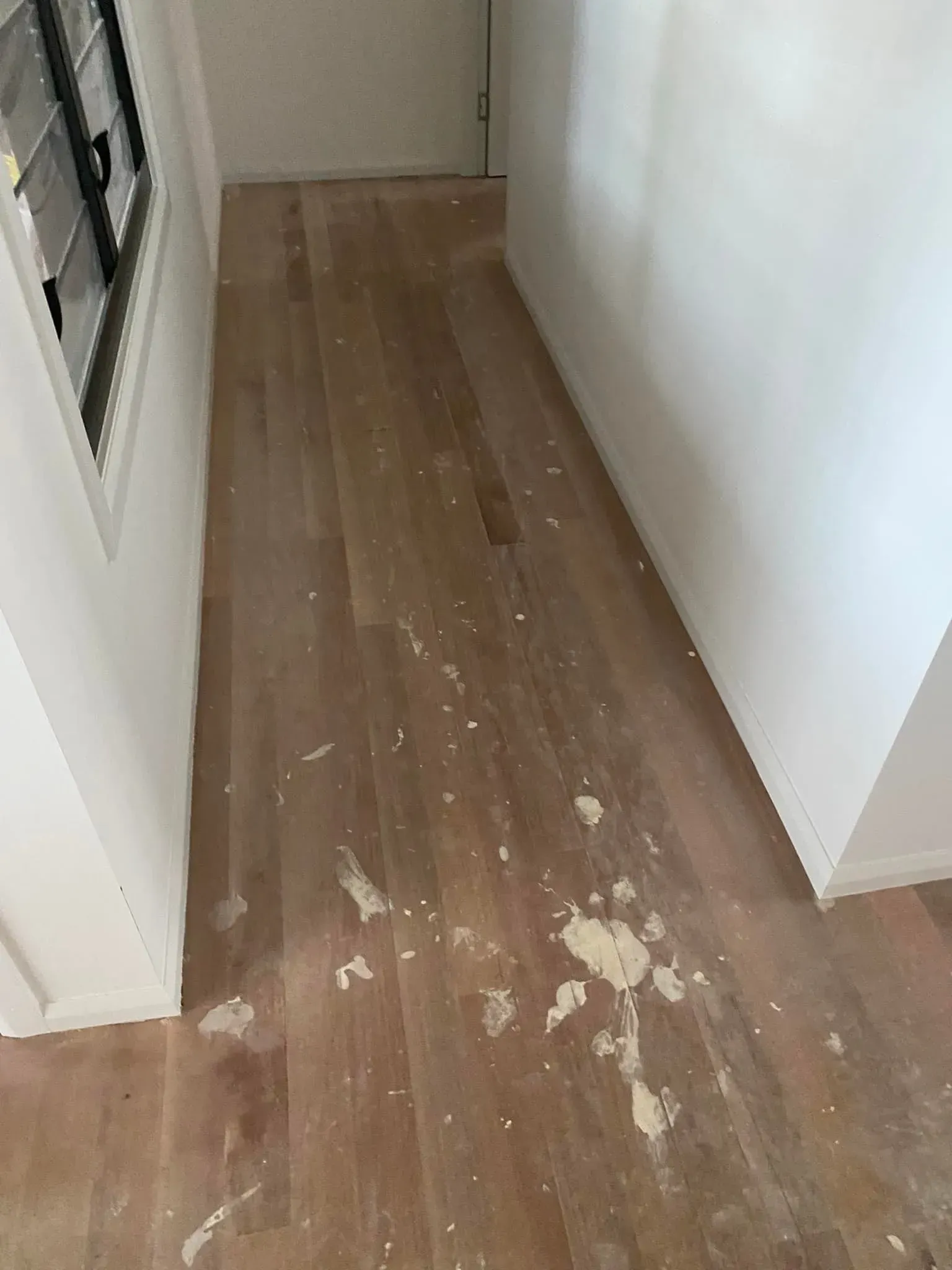 A Hallway With A Wooden Floor And White Walls — AJ's Cleaning & Floor Sanding In Woree, QLD