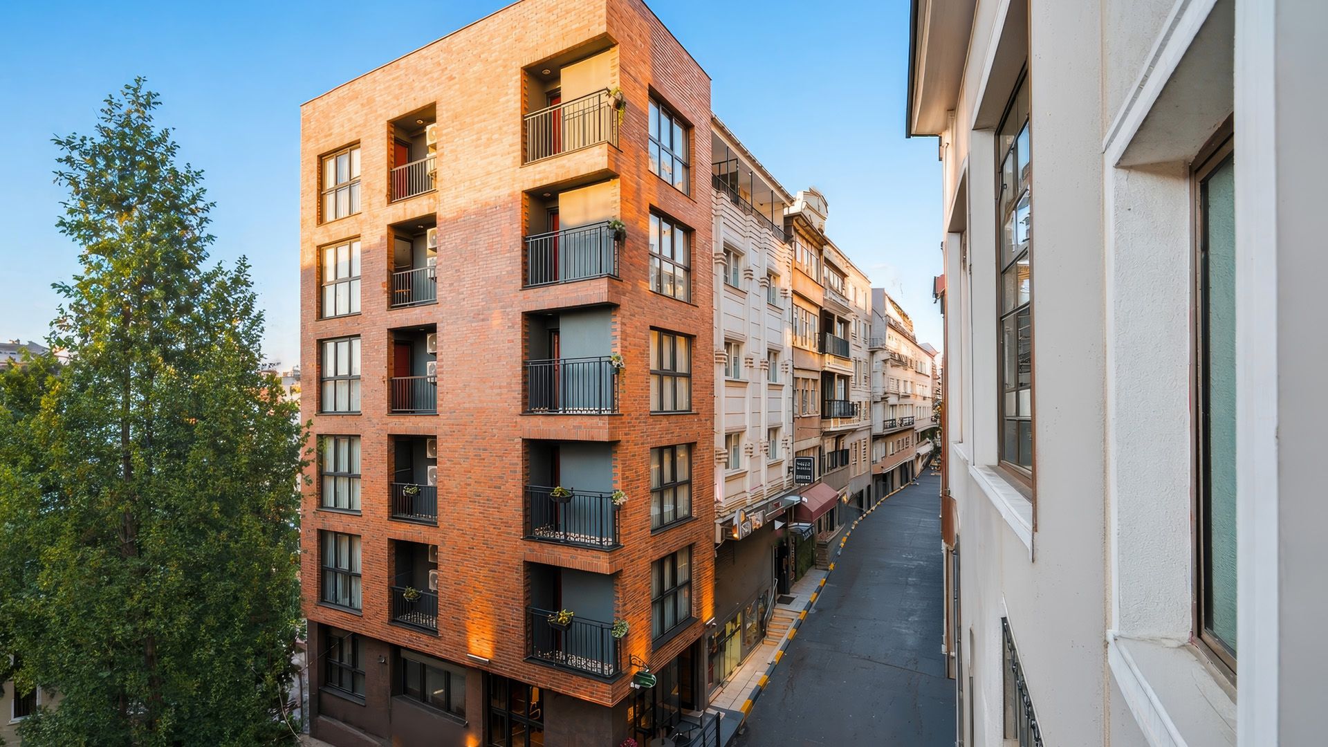 ARTELIST HOTEL | Modern brick apartment buildings along a narrow street, seen from an elevated angle