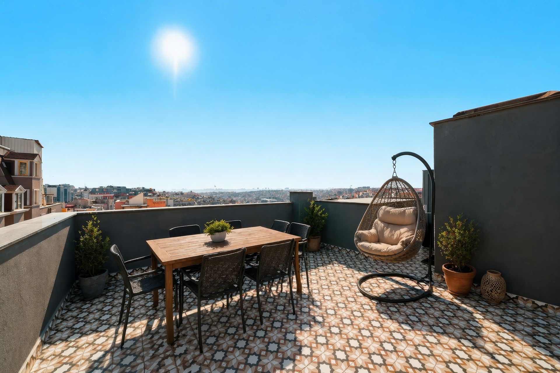 ARTELIST HOTEL | Rooftop terrace with table, hanging chair, potted plants, and city view under a bright blue sky