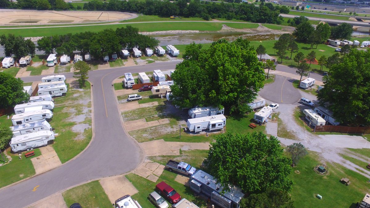 An aerial view of a campground with a lot of rvs parked in the grass.