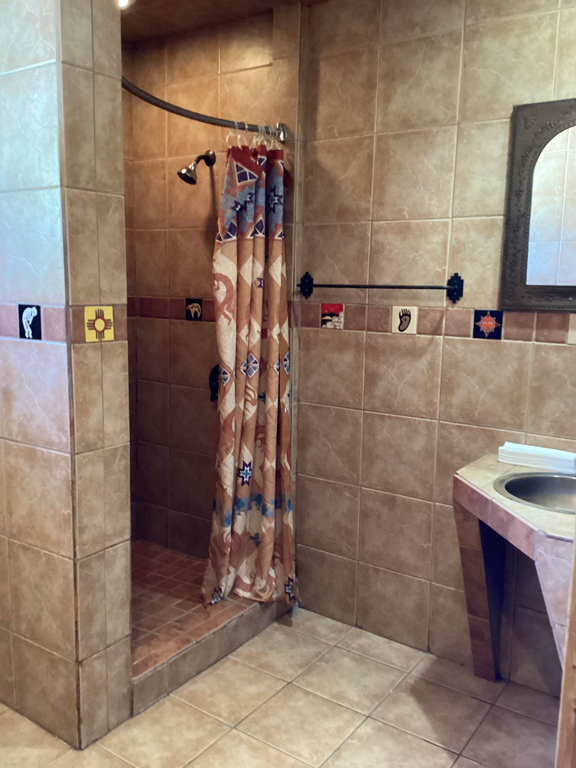 A bathroom with a walk in shower and a sink