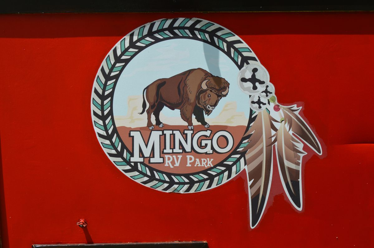 A logo for mingo rv park with a bison and feathers