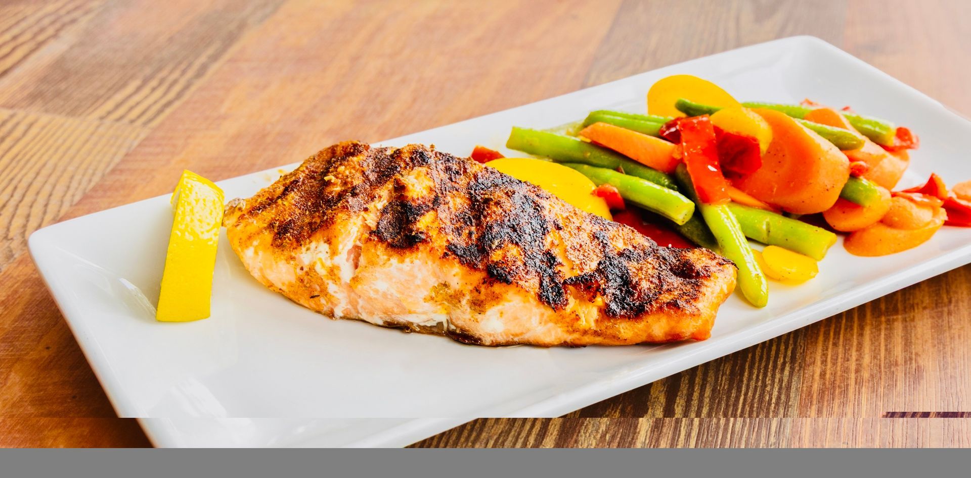 Grilled chicken breast with colorful steamed vegetables on a white plate