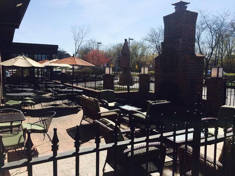 A patio with tables and chairs and umbrellas on a sunny day
