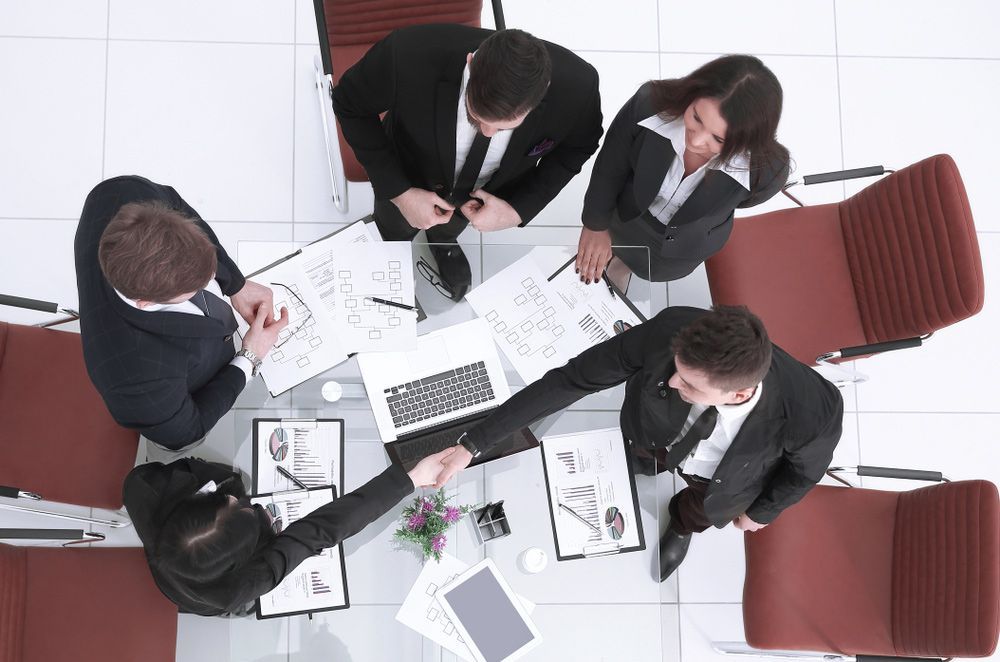 Business People Shaking Hands and Standing by a Table — Clarence Property Consultants In Grafton, NSW