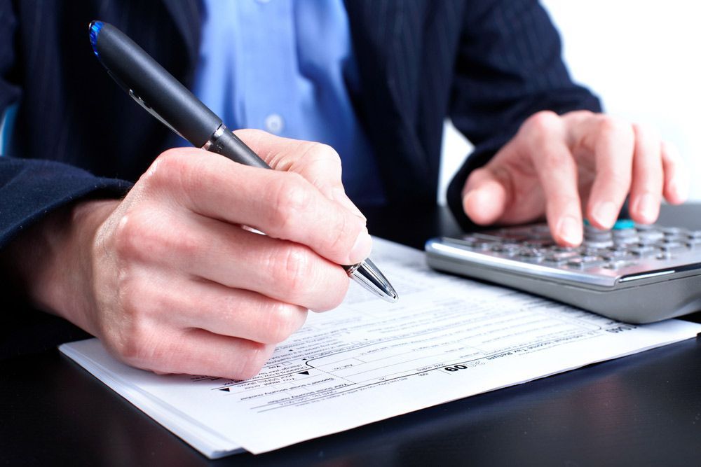 Male Hand with a Pen and for with Calculator — Clarence Property Consultants In Grafton, NSW