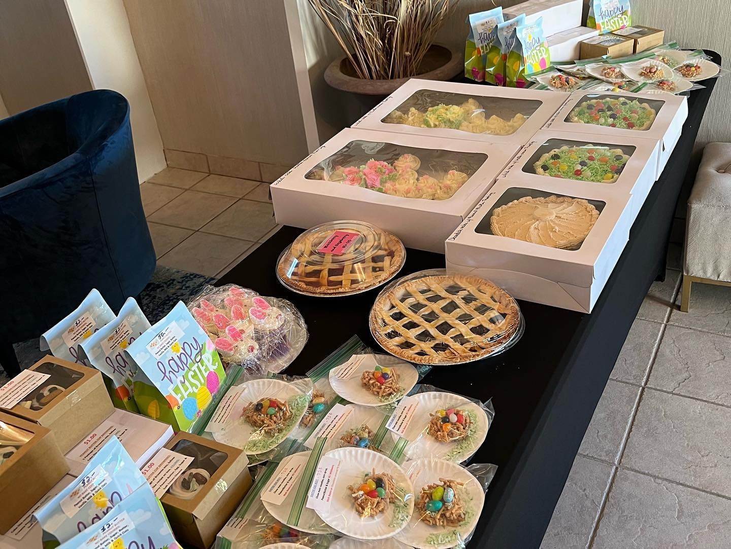 Desserts, pies, and packaged treats arranged on a table at a food stall