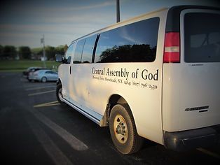 White church van parked in a lot at sunset, labeled “Central Assembly of God.”