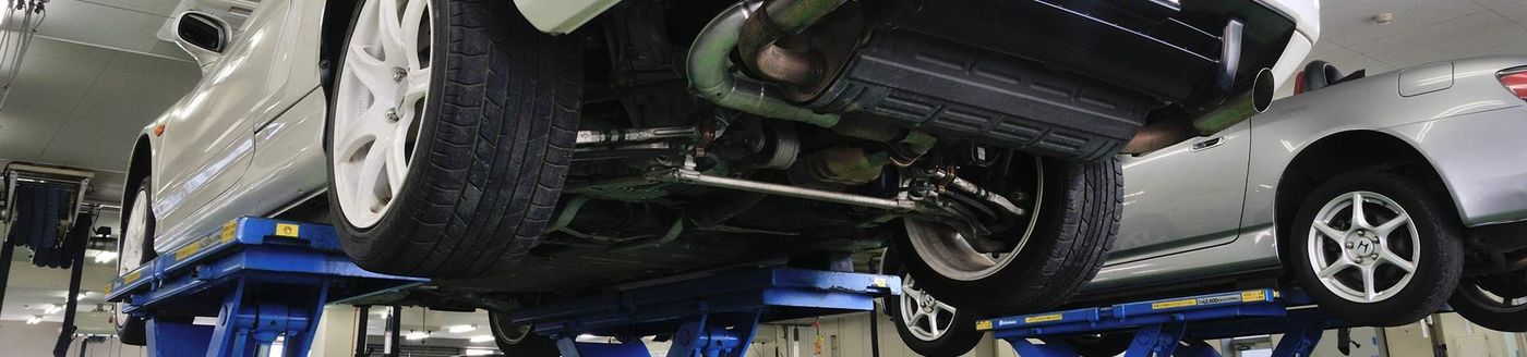 A car is being lifted on a lift in a garage - A Street Automotive