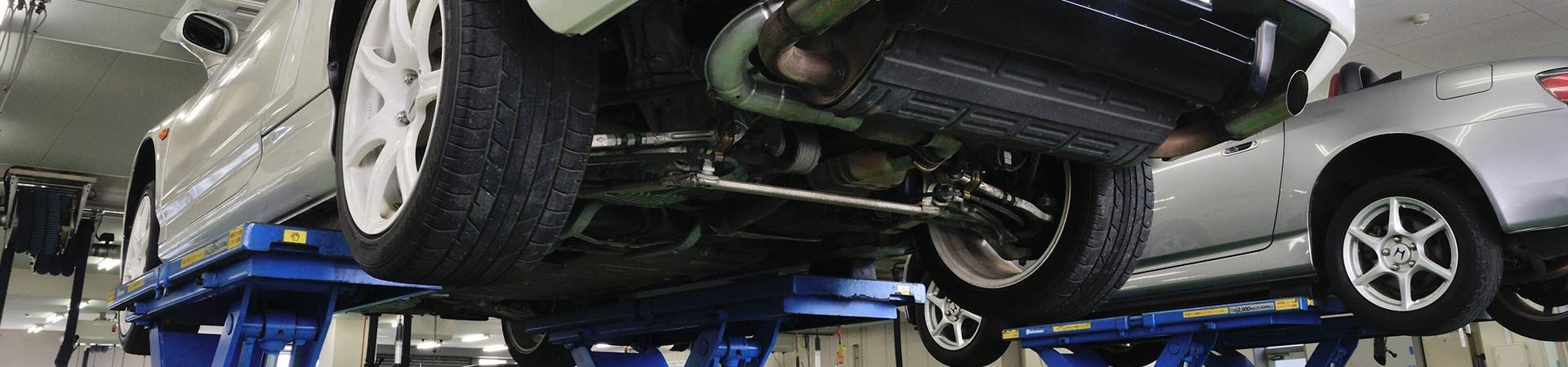 A car is being lifted on a lift in a garage - A Street Automotive