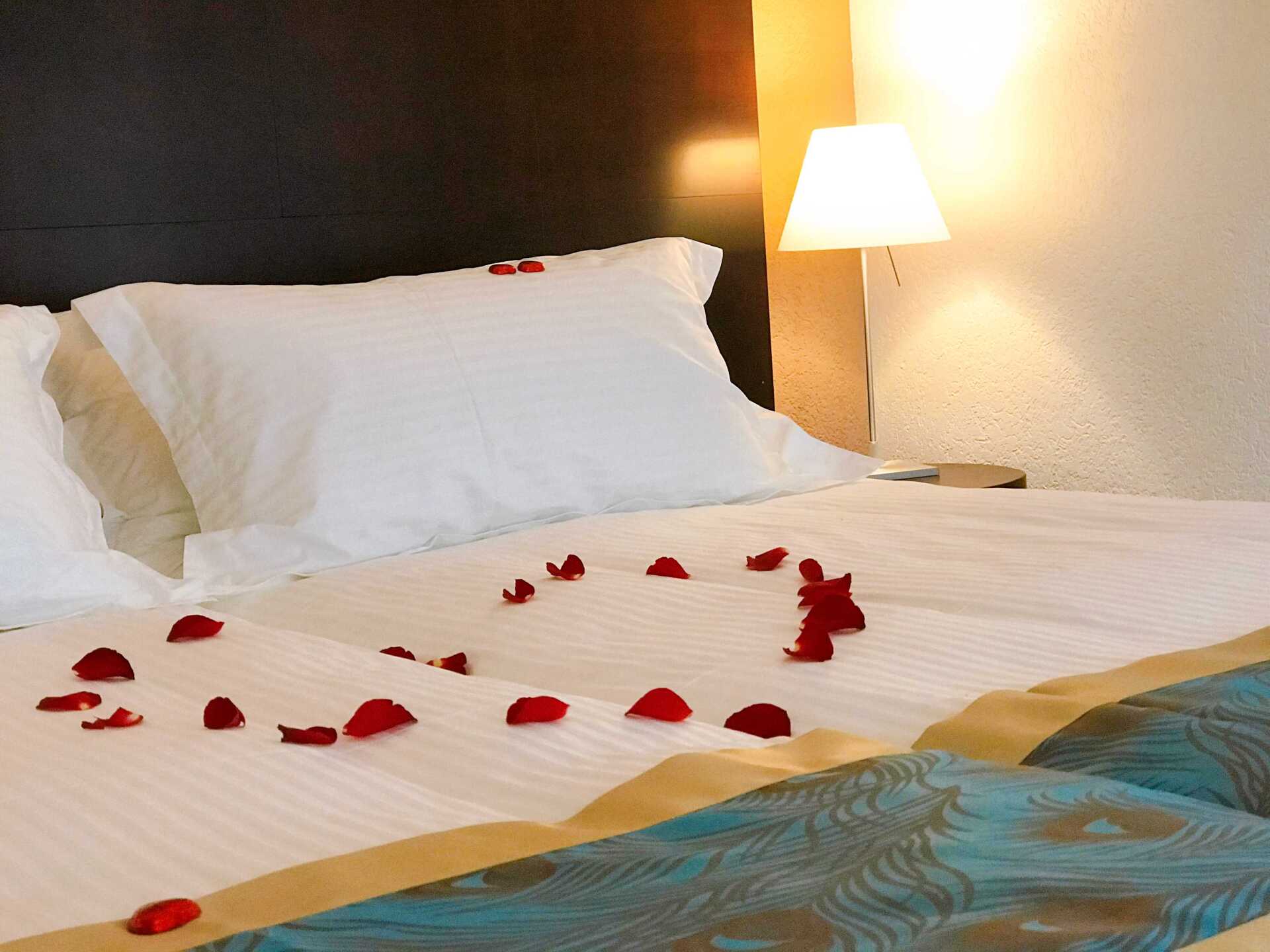 Deluxe-Zimmer mit Rosenblättern auf der Bettdecke