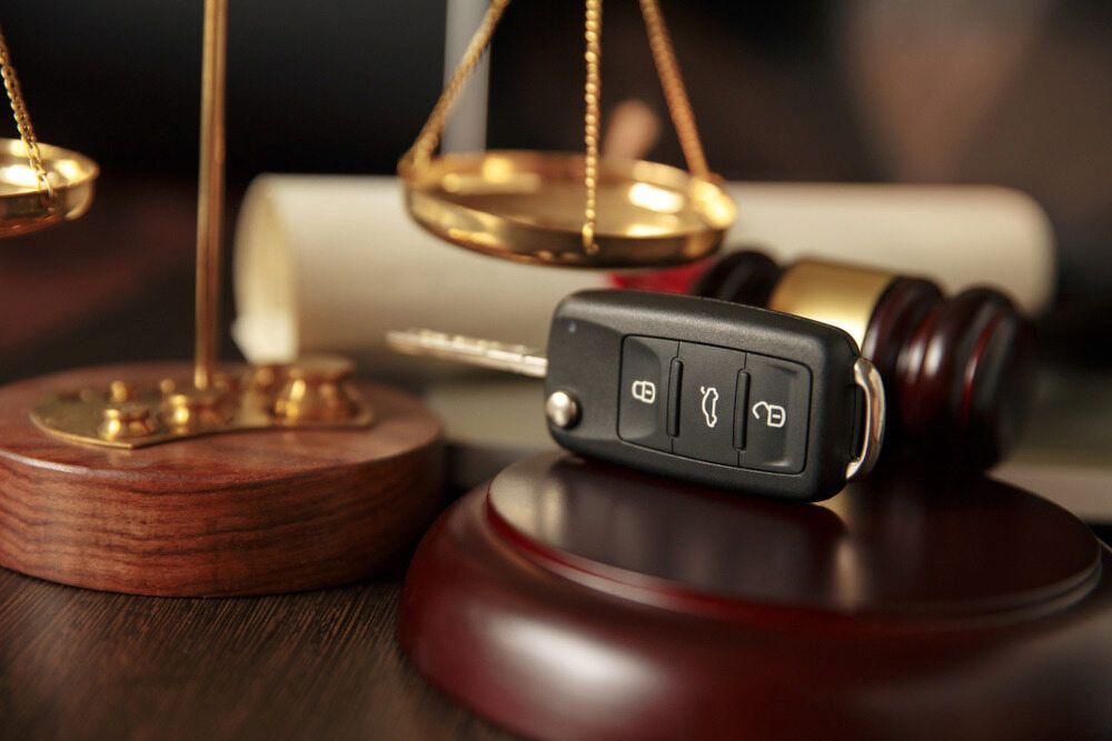 Car Key on a Judge's Gavel Next to Scales of Justice, Suggesting a Legal Context — Bradley Solicitors in Larrakeyah, NT