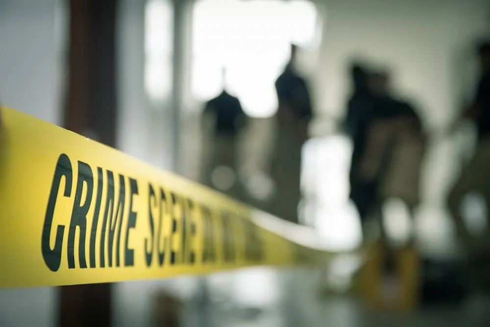 Yellow Crime Scene Tape Blocks an Indoor Area; Blurred Figures — Bradley Solicitors in Larrakeyah, NT
