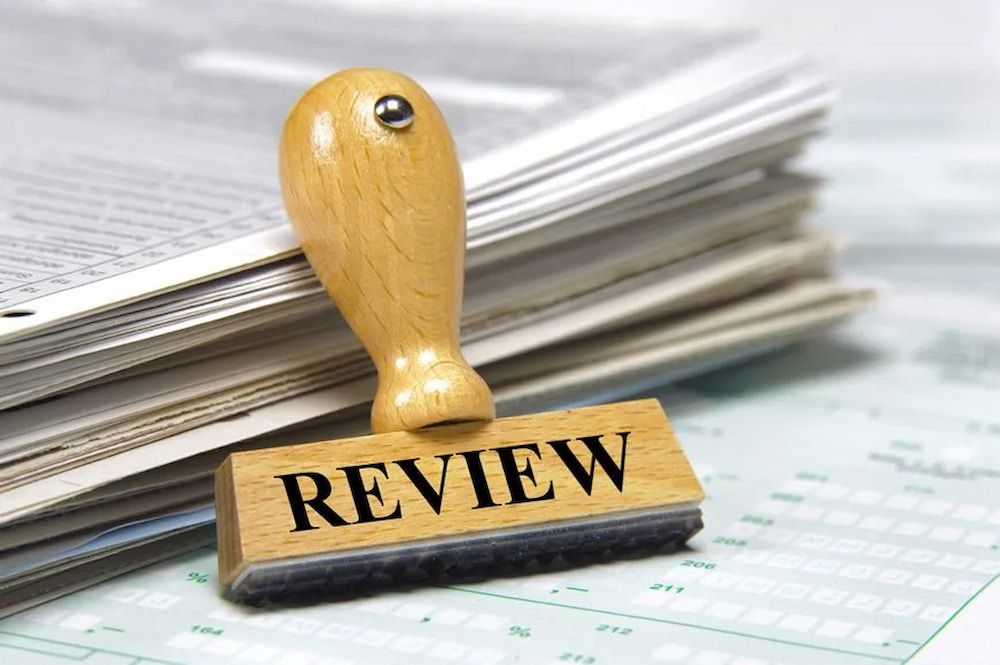 Wooden Review Stamp on Stack of Documents — Bradley Solicitors in Larrakeyah, NT