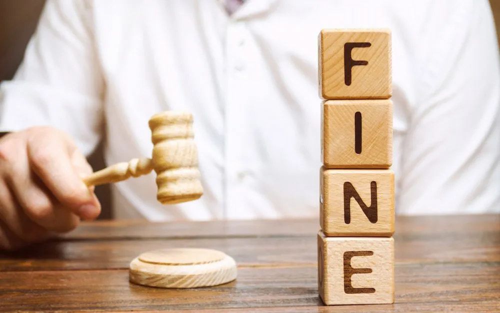 Person With Gavel Beside Wooden Blocks Spelling FINE— Bradley Solicitors in Larrakeyah, NT