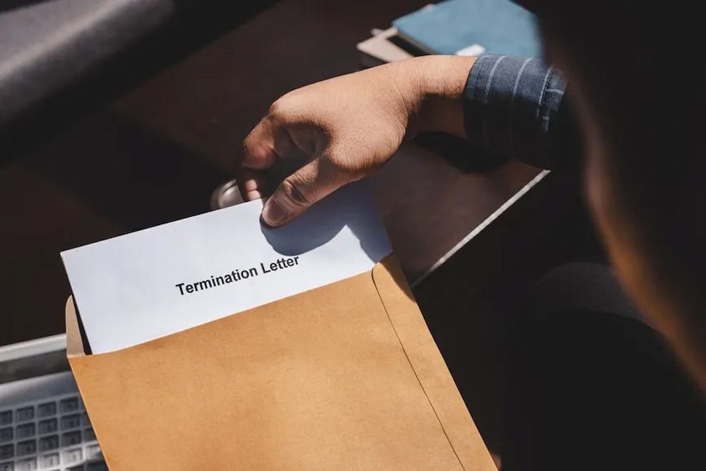 Person Removes Termination Letter From a Brown Envelope — Bradley Solicitors in Larrakeyah, NT