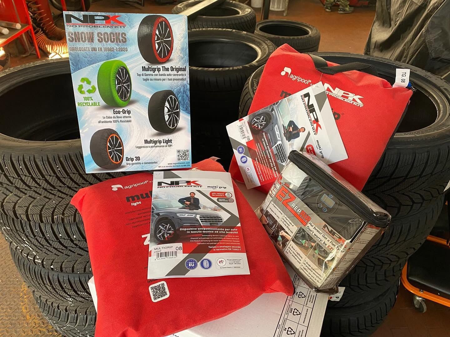 Pneumatici per auto impilati attorno a cuscini rossi e accessori per pneumatici in scatola in esposizione.