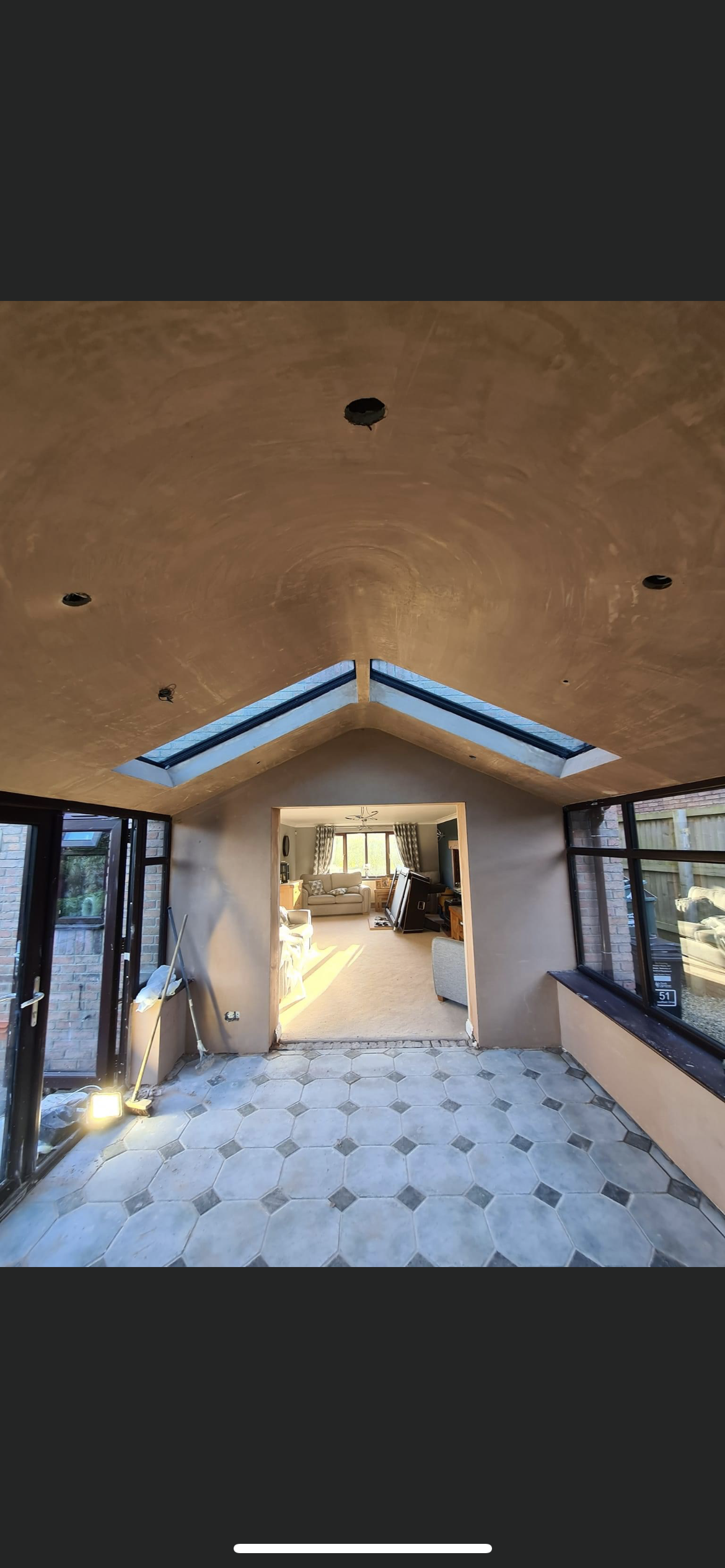 A room with a vaulted ceiling and a lot of windows.