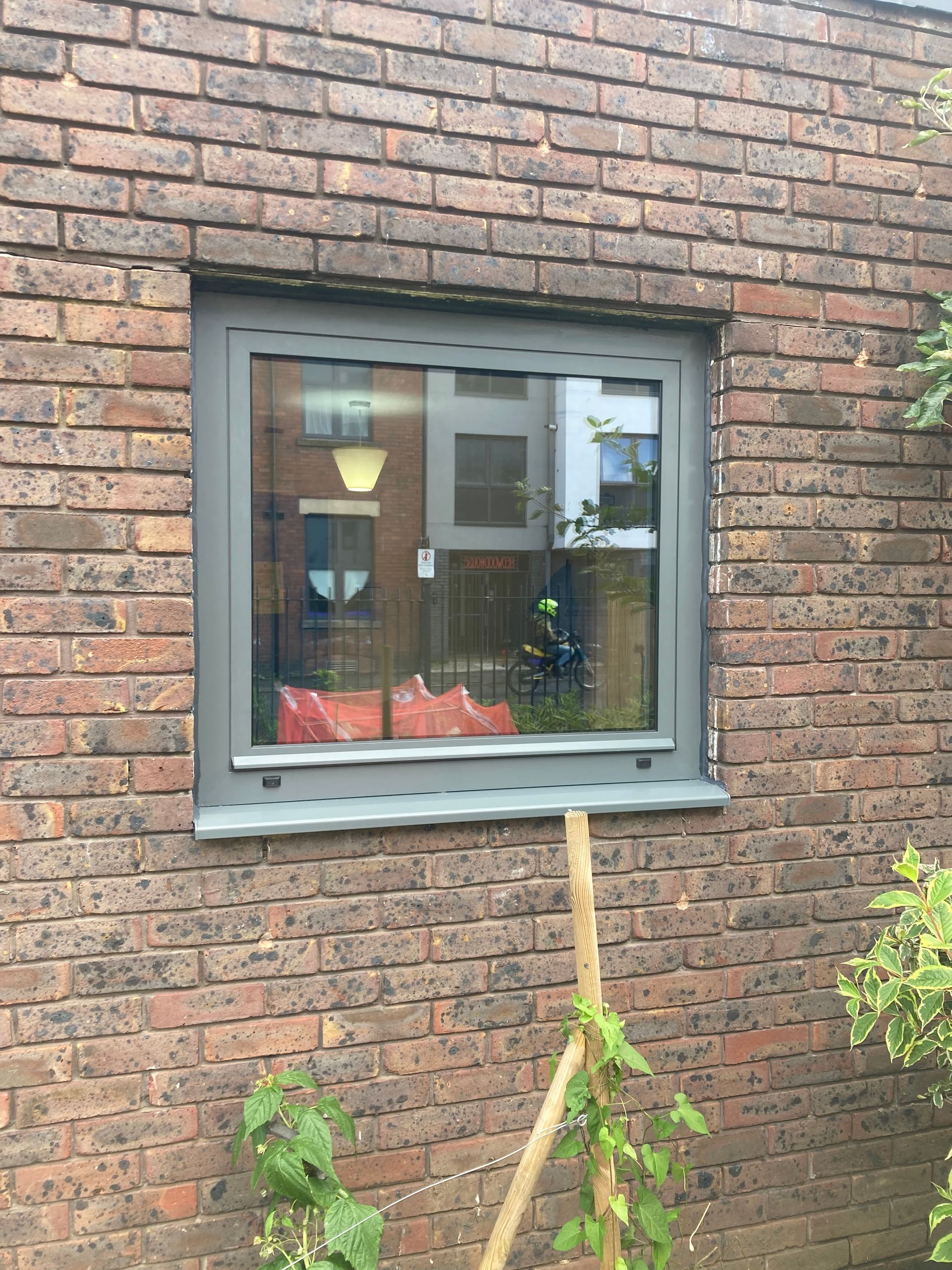 There is a window on the side of a brick building.