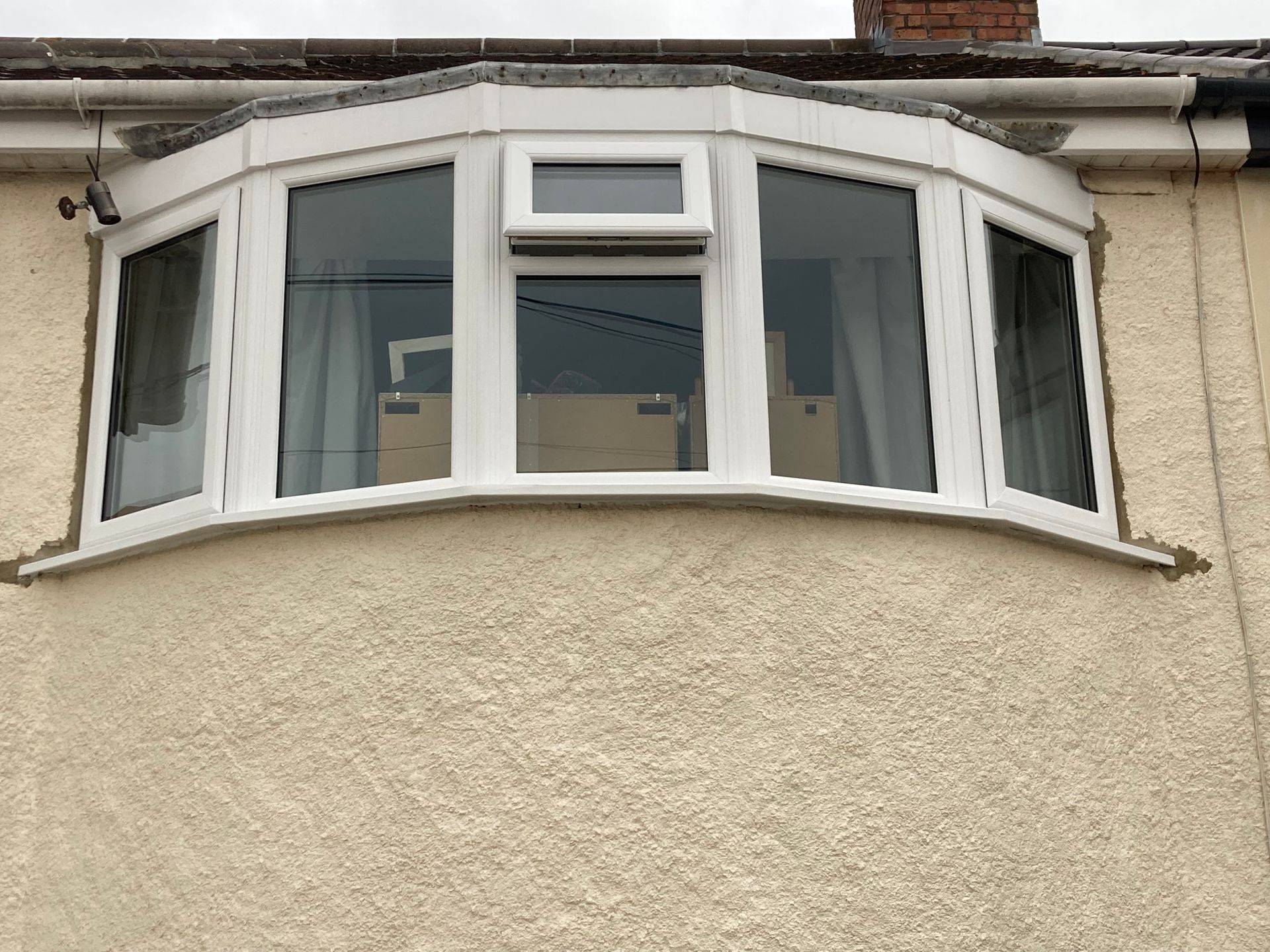 A white bay window on the side of a house.