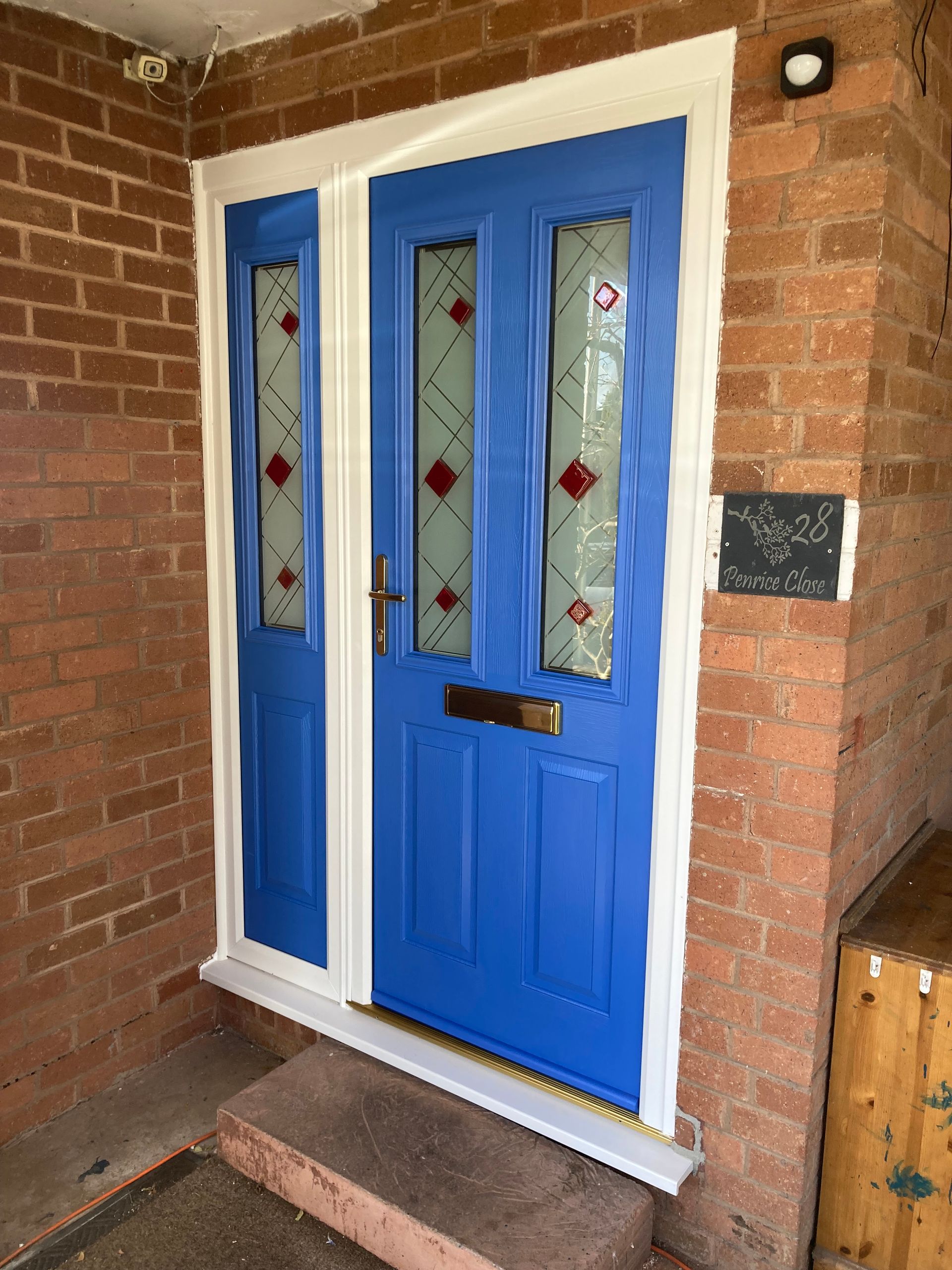 A blue door with a white trim is on a brick wall.