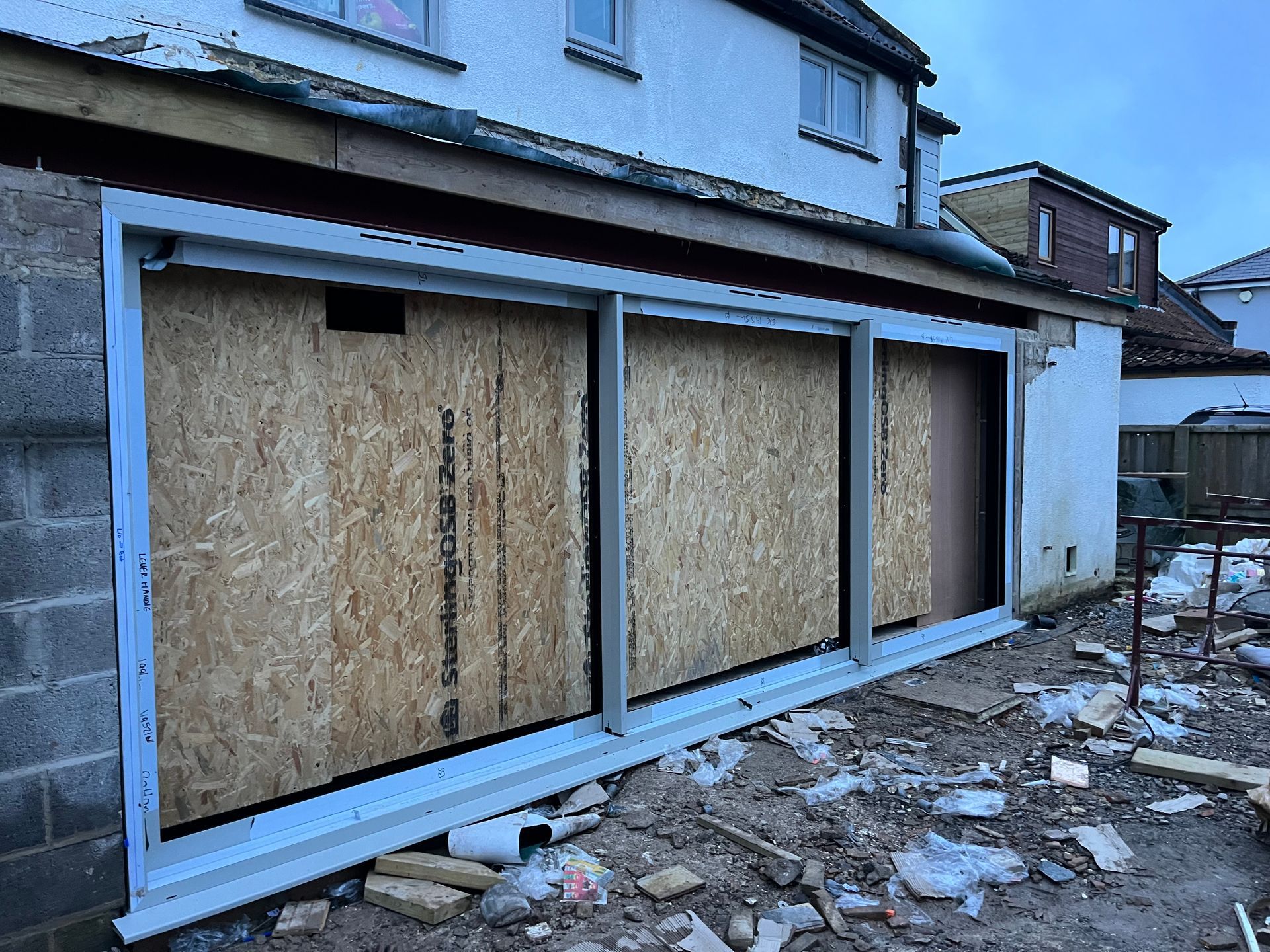A house is being remodeled and the windows are boarded up.