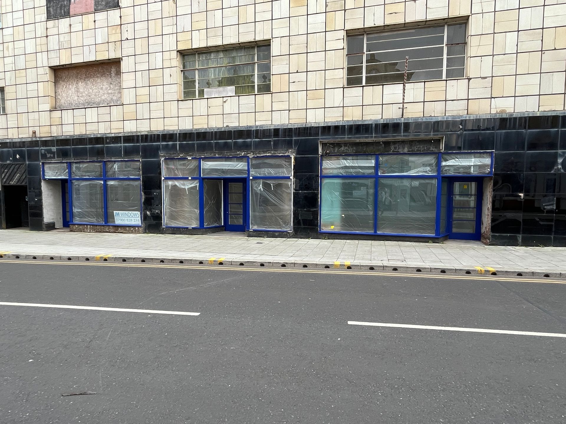A building with a lot of windows is on the side of the road