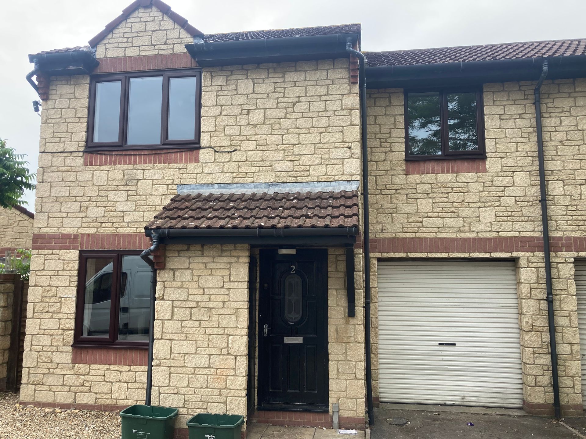 A large brick house with a garage and a black door