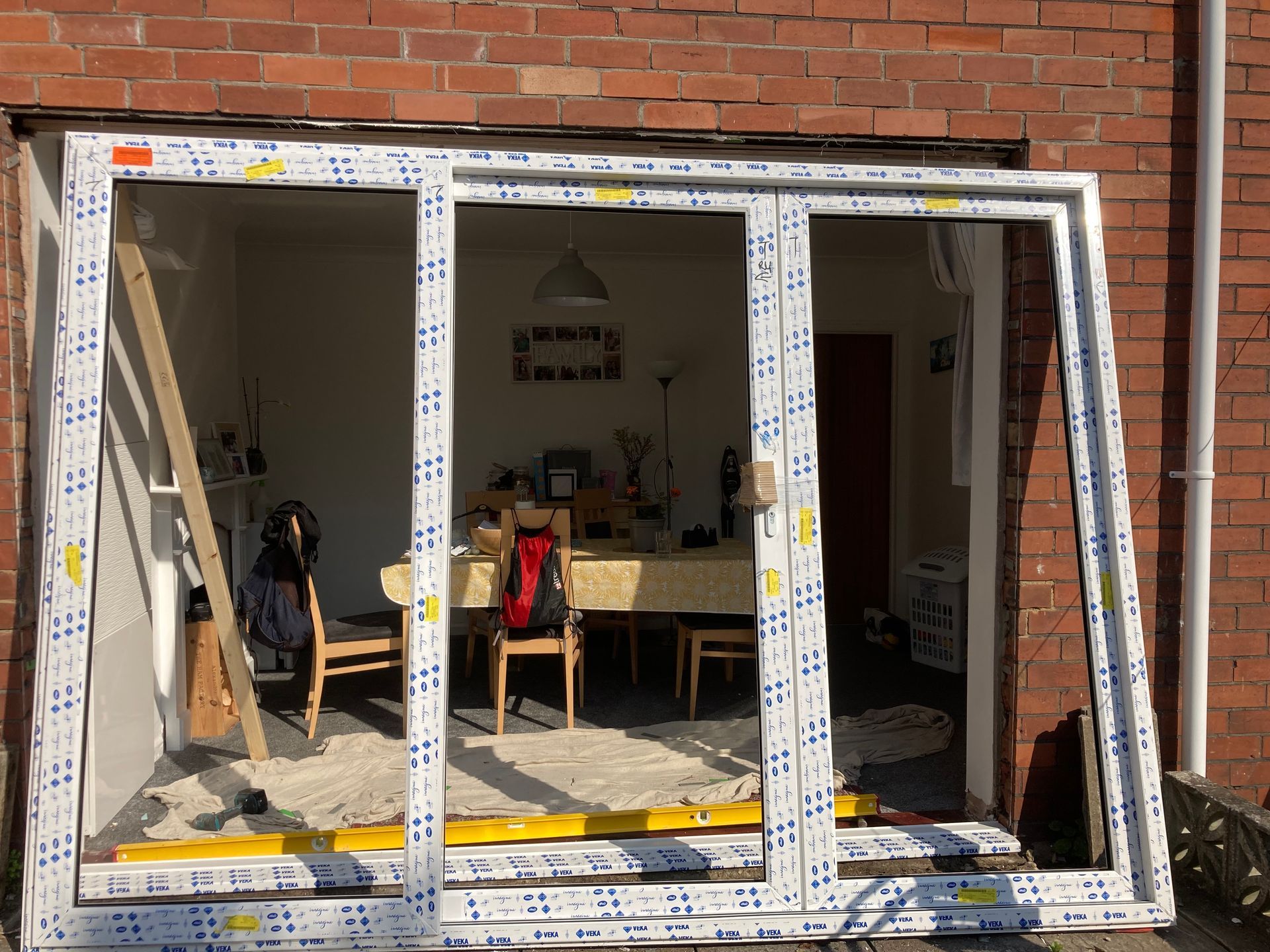 A sliding glass door is being installed in a brick house.