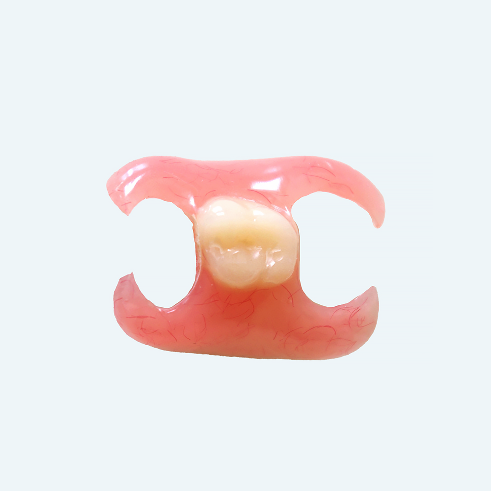 Partial denture with one tooth, pink base, cream-colored tooth.