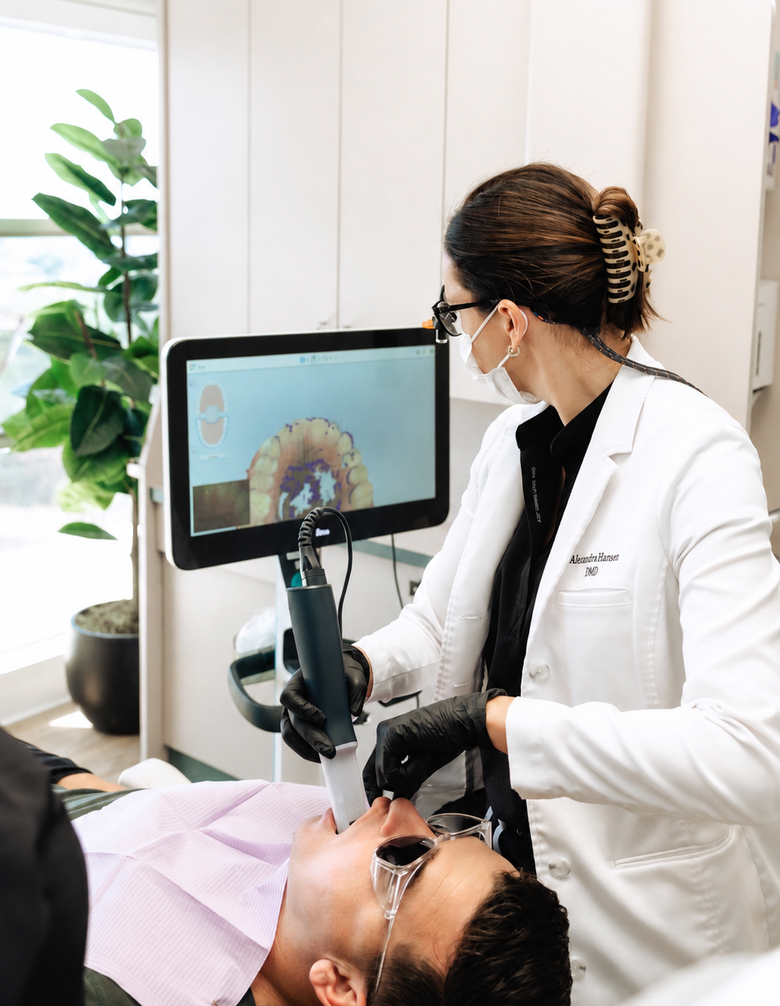 Dentist pointing at teeth scan on screen, explaining to patient reclining in chair, dental office.