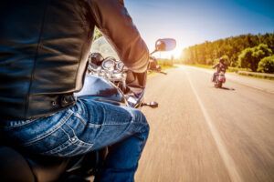 A man is riding a motorcycle down a road.