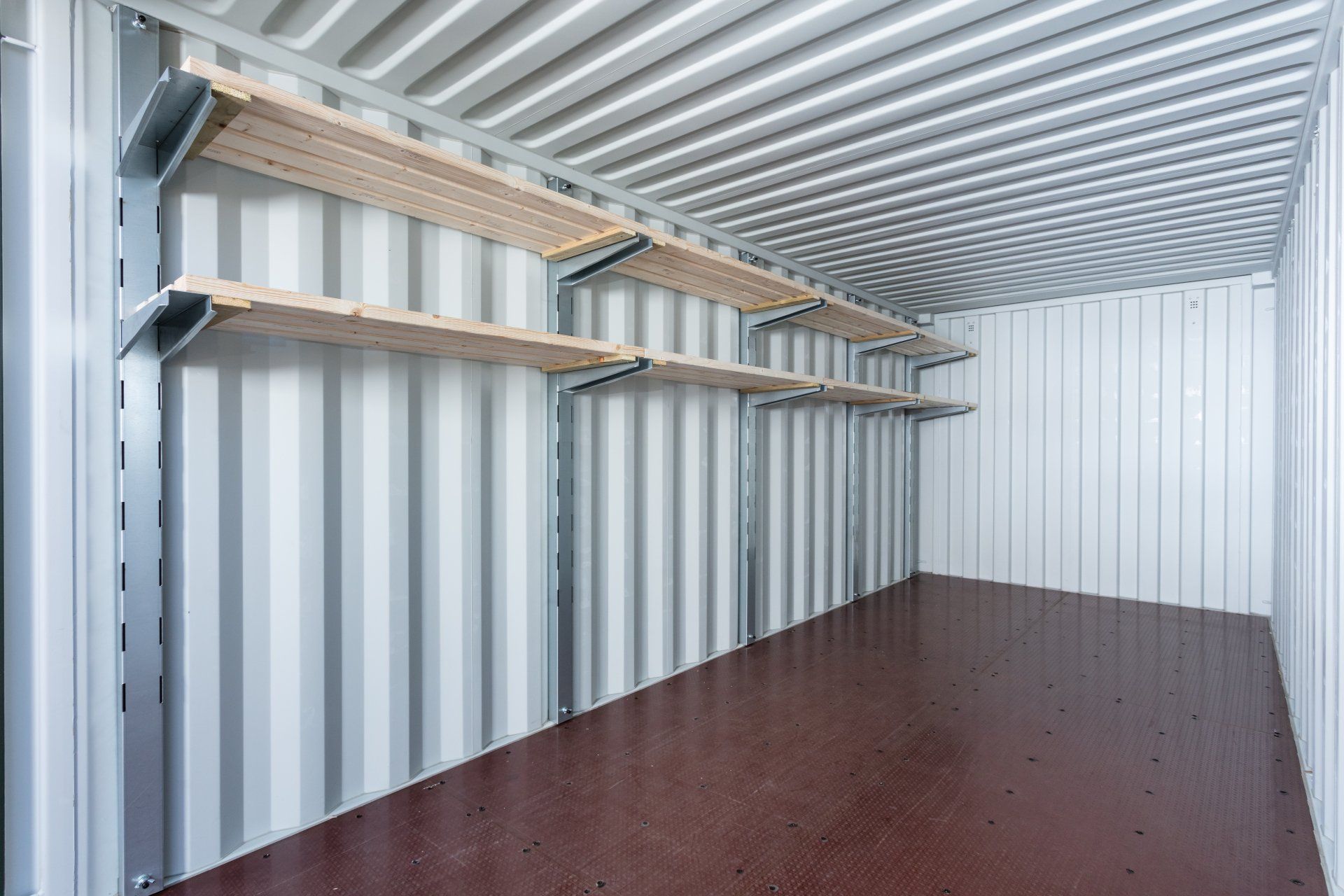 Empty storage container interior with shelving along a side wall.