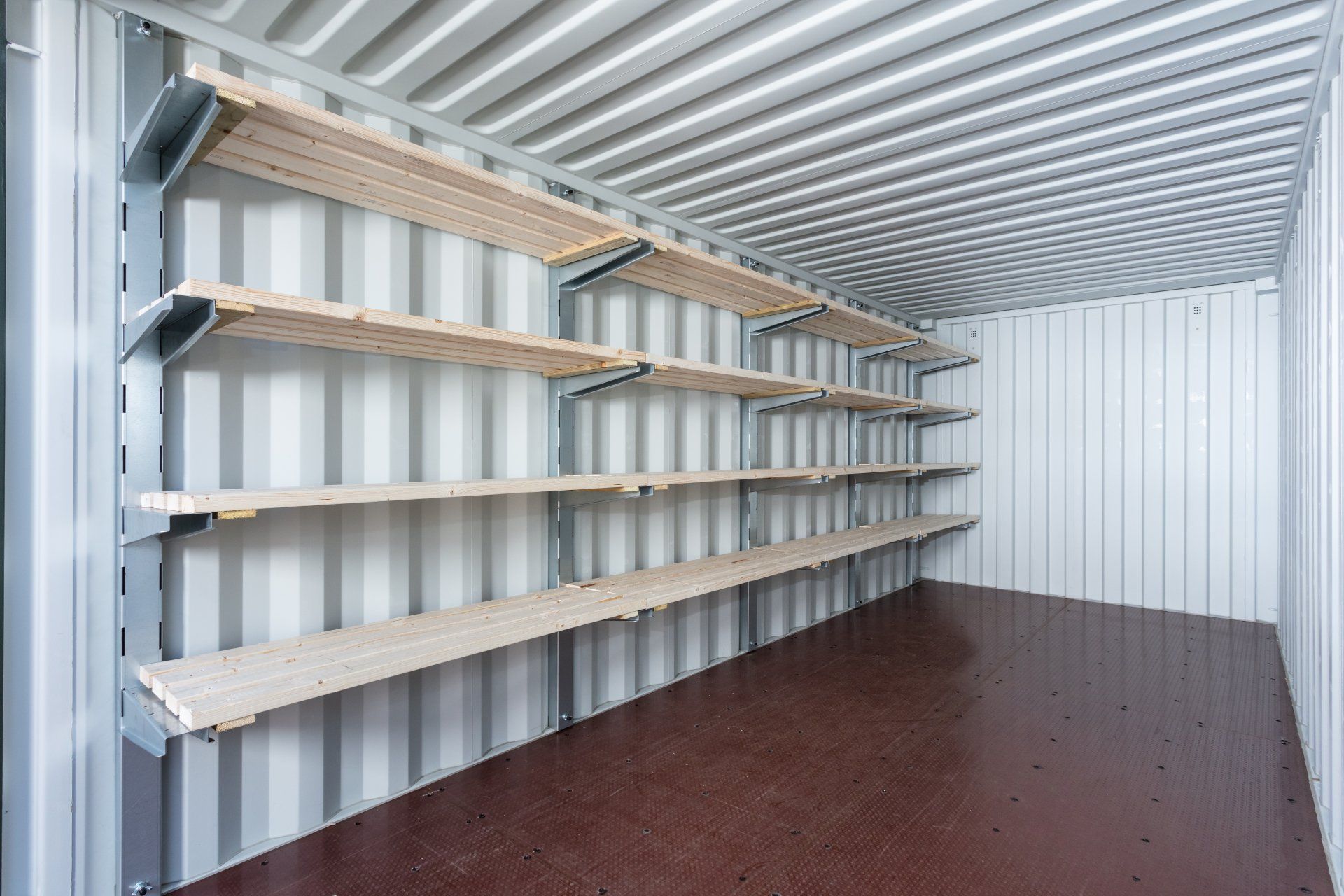 Interior of a storage container with multiple wooden shelves attached to the side walls.