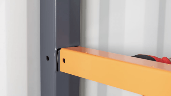Orange shelf beam inserted into a gray vertical support within a white corrugated setting.