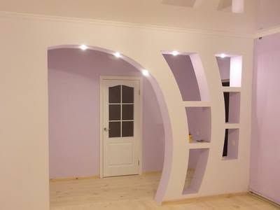 Interno di una stanza moderna con pareti color lavanda, divisorio ad arco e porta bianca sullo sfondo.