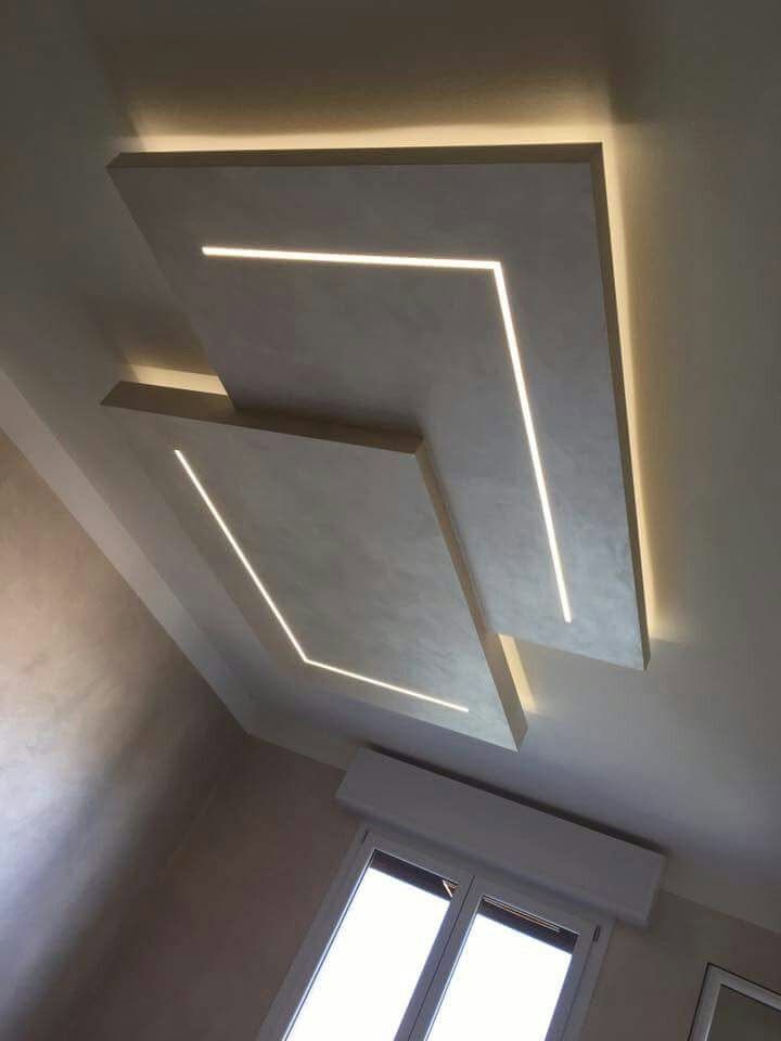Lampada da soffitto dal design moderno con strisce LED luminose posizionate sopra una finestra.