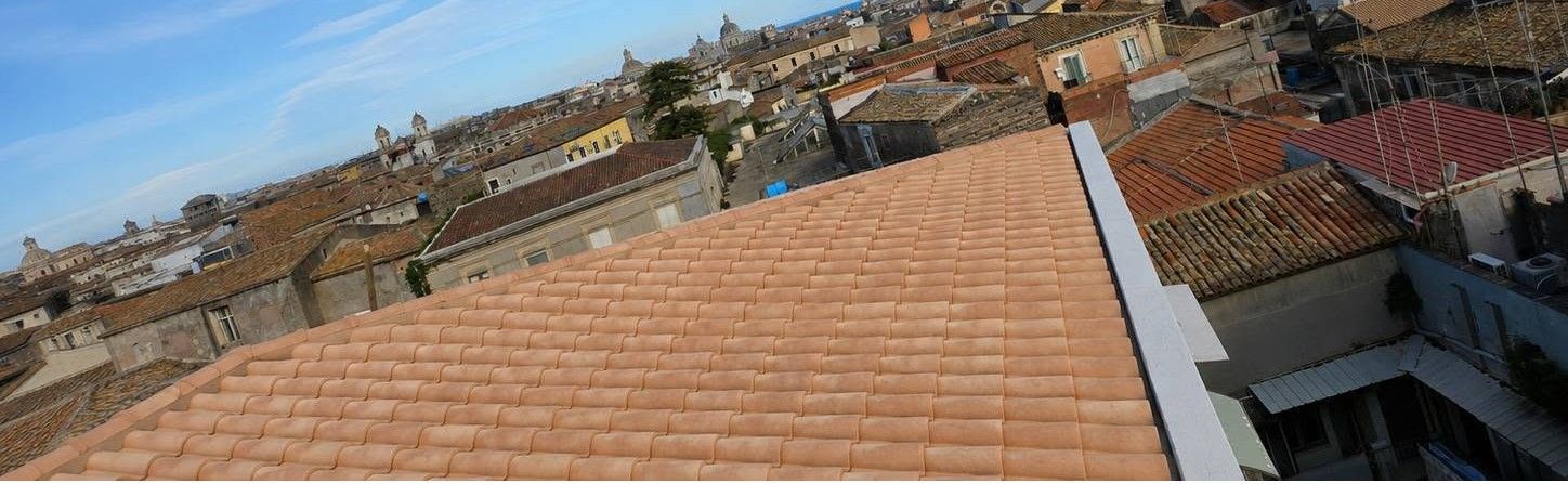 I tetti di una città sotto un cielo azzurro e limpido, visti dall'alto in una giornata di sole.