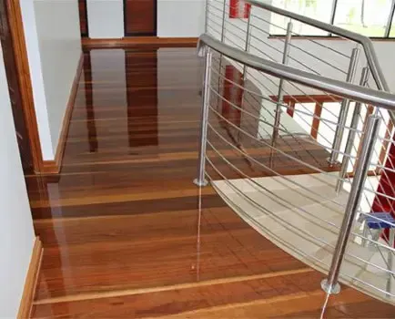 A Wooden Staircase With a Stainless Steel Railing — Timbertop Floor Sanding & Polishing In Bungalow, QLD