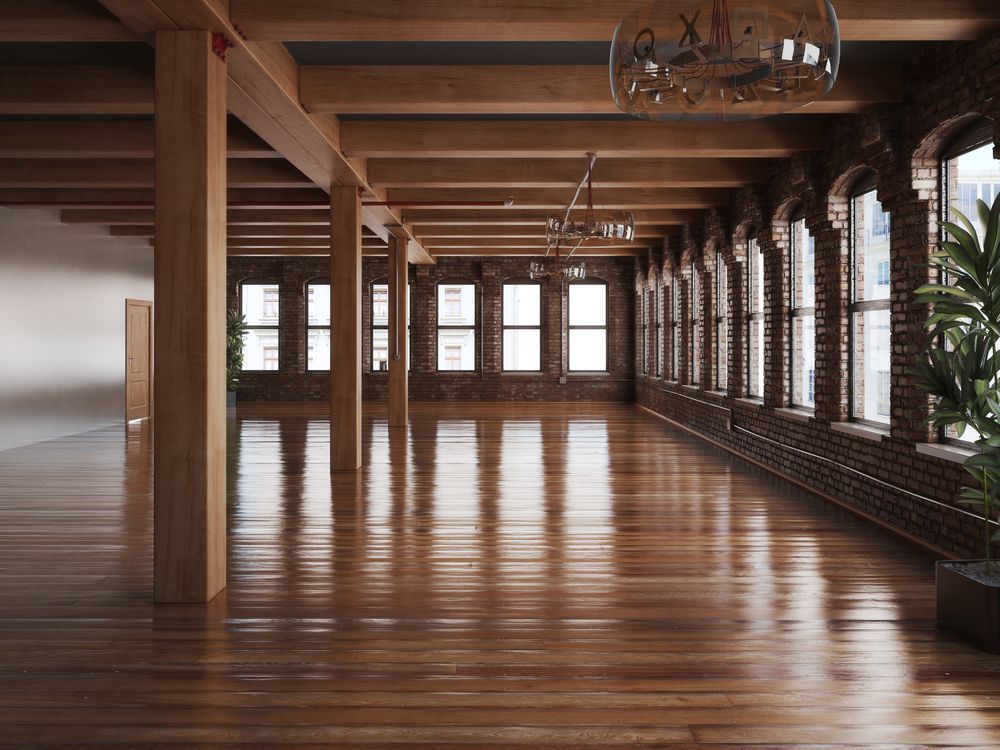 An Empty Room With a Lot of Windows and Wooden Floors — Timbertop Floor Sanding & Polishing In Cassowary Coast, QLD