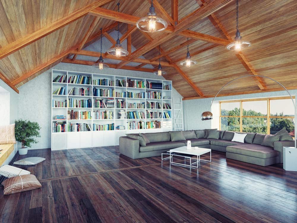 A Living Room With a Large Sectional Couch and a Large Bookshelf — Timbertop Floor Sanding & Polishing In Port Douglas, QLD