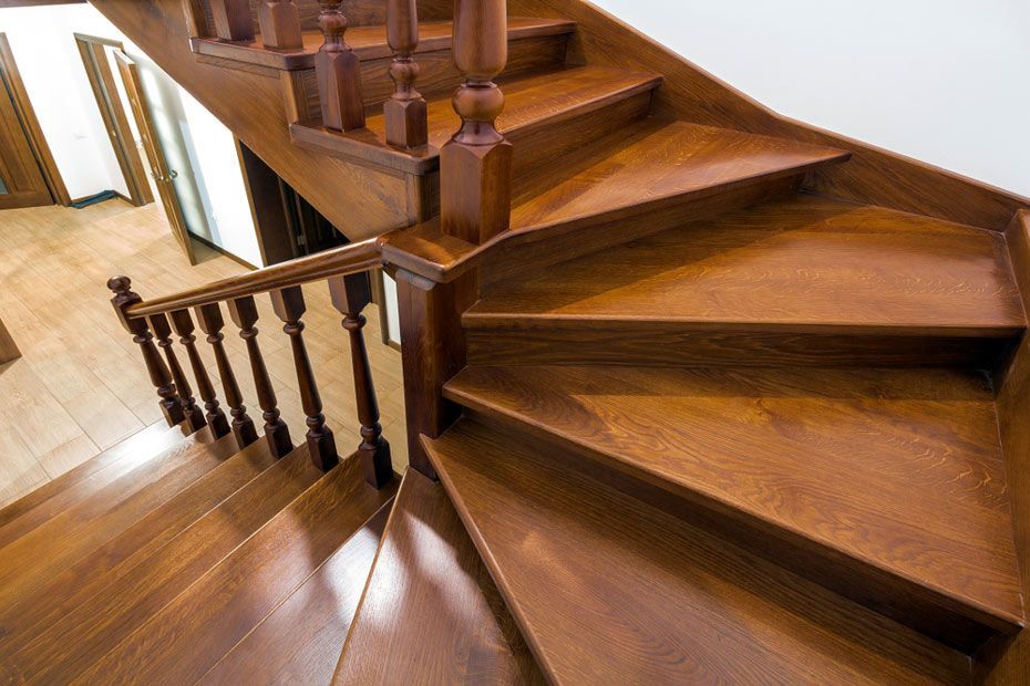 A Wooden Spiral Staircase With a Wooden Railing in a House — Timbertop Floor Sanding & Polishing In Cairns, QLD