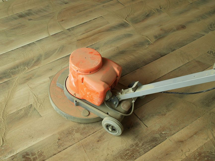 A Machine is Being Used to Polish a Wooden Floor — Timbertop Floor Sanding & Polishing In Bungalow, QLD