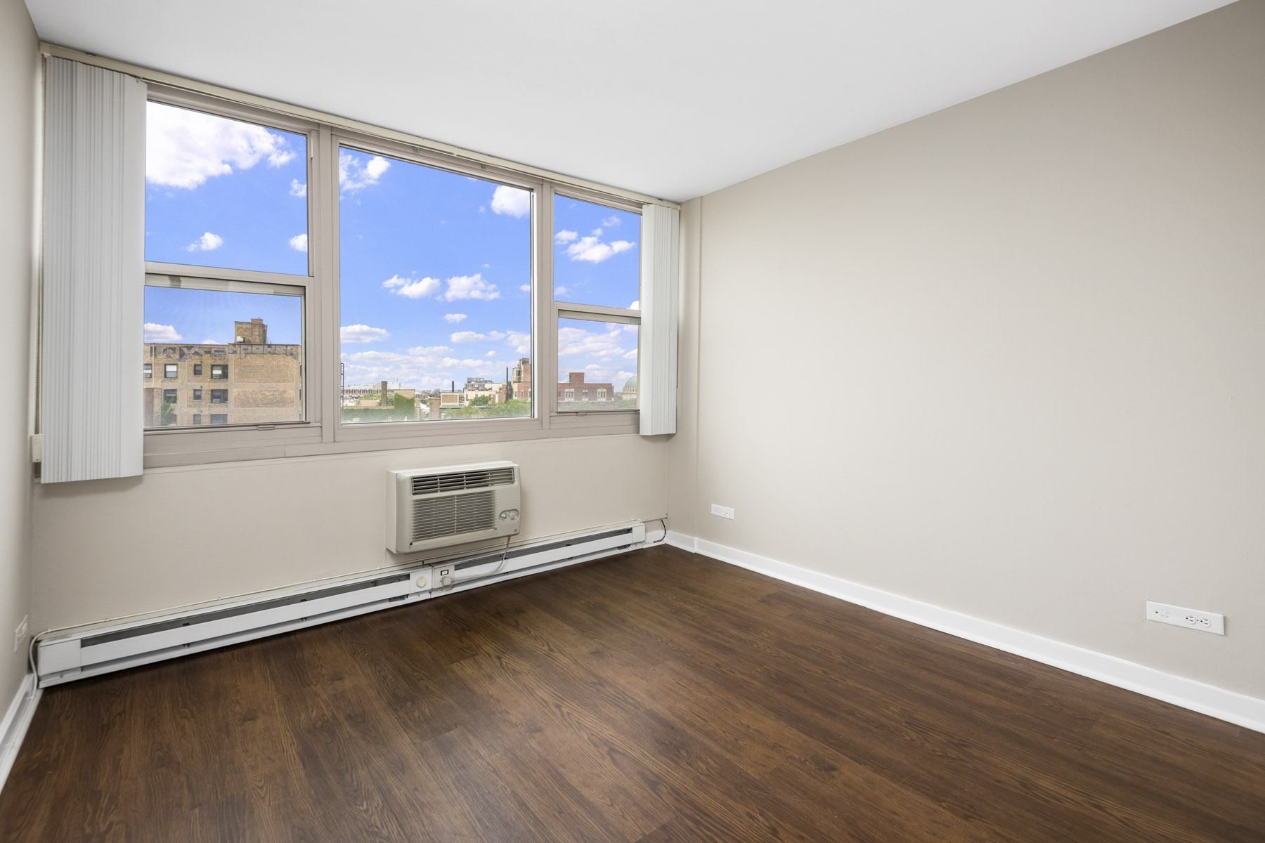 an empty room with wood floors and a window