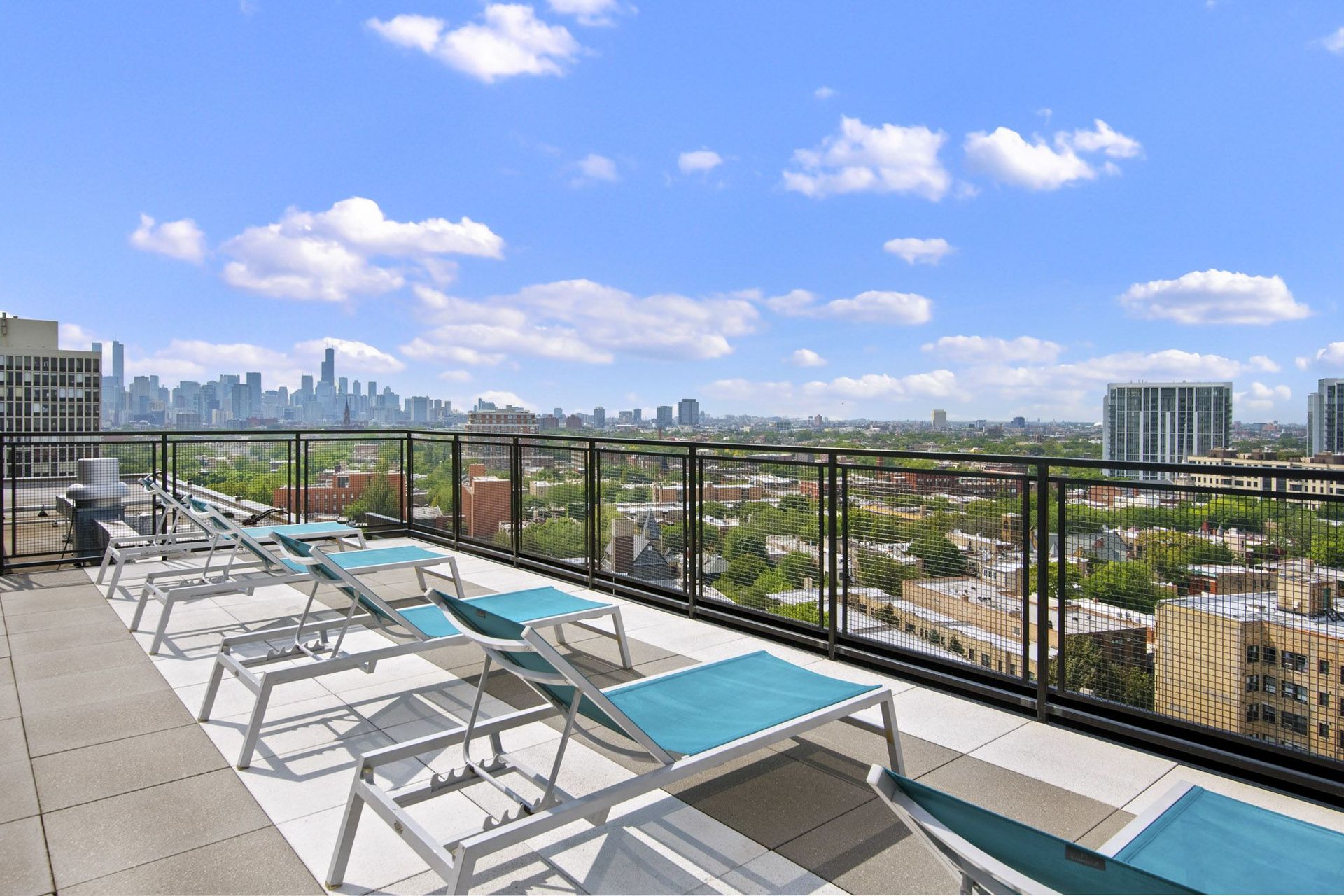 a view of the city from a rooftop patio with tables and chairs
