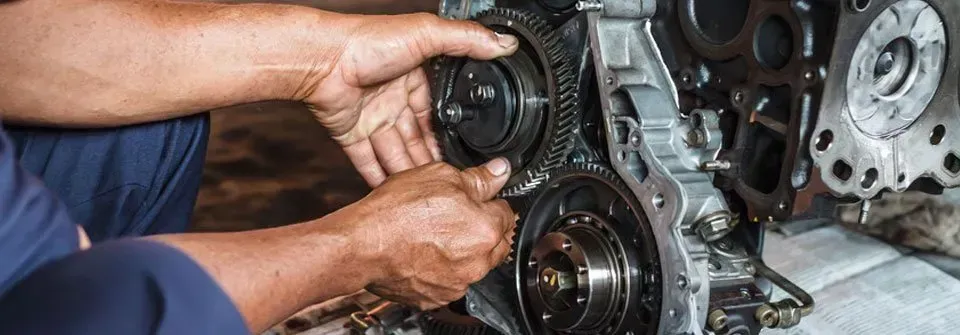 A man is working on a car engine in a garage.