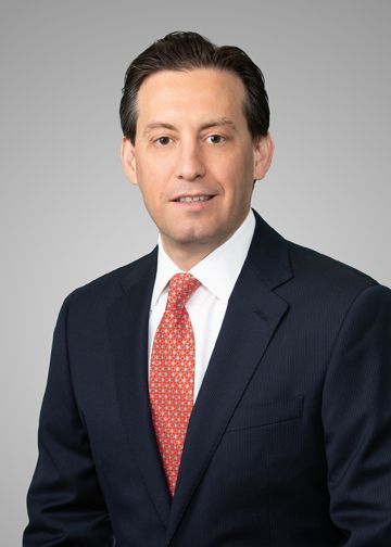 A man in a suit and tie is smiling for the camera.