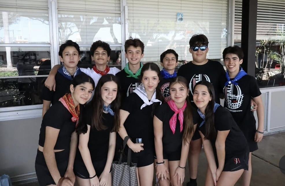 A group of girls wearing shirts that say sticks
